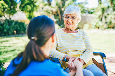 Nurse with patient on a bench outdoors